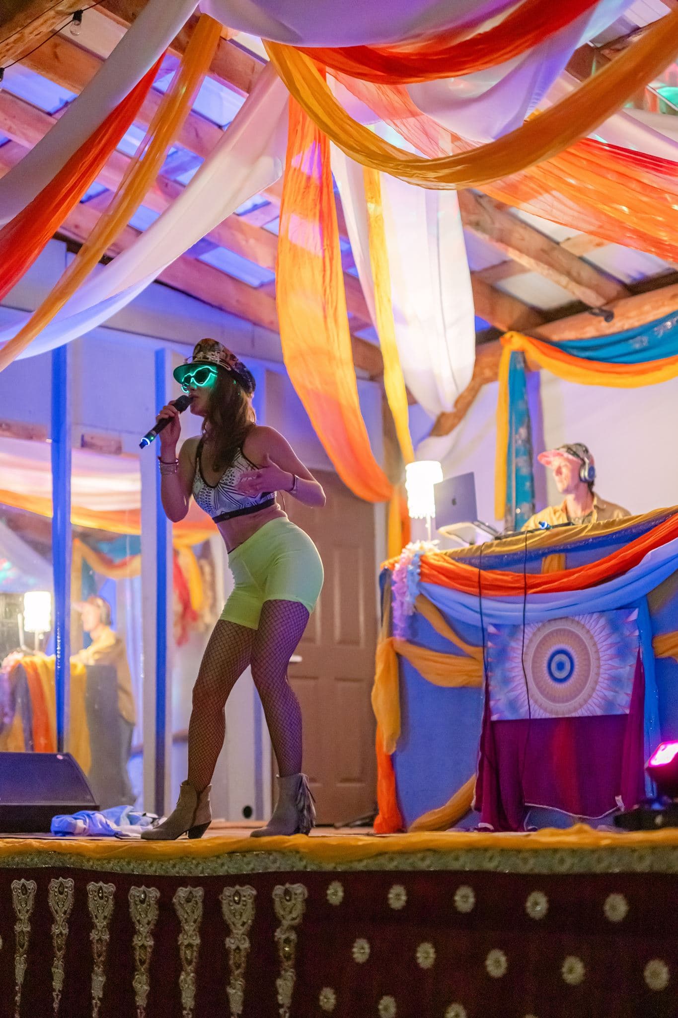Lara Brightside singing on a colourful festival stage.