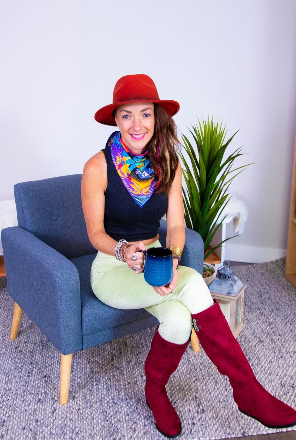 Lara Brightside smiling in a red hat and colourful scarf.